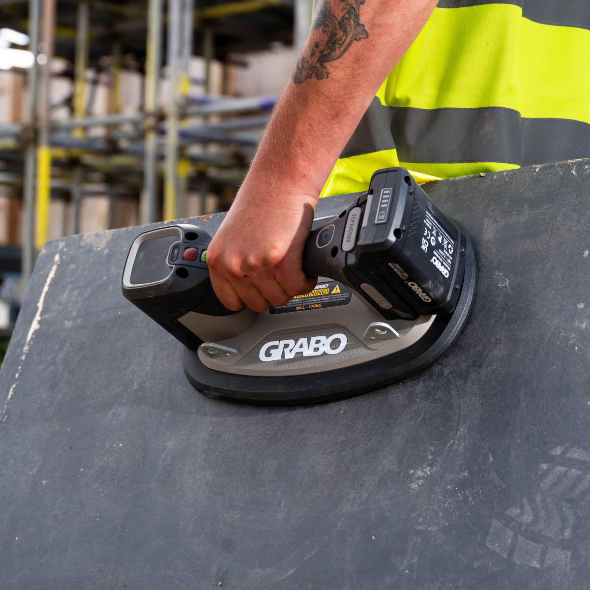 Person using a GRABO tool on a surface in an industrial setting